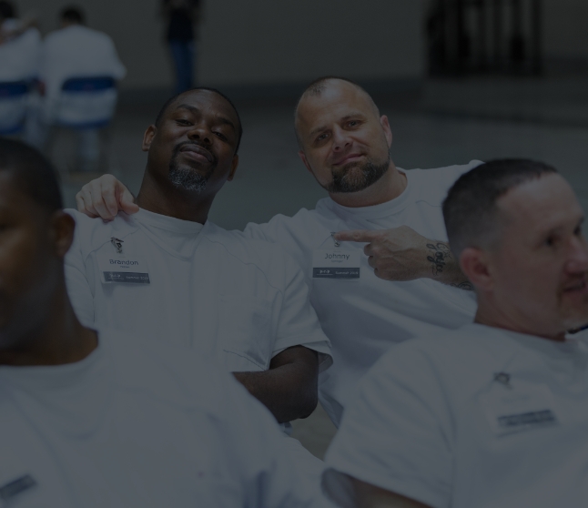Two men in white uniforms smiling and posing together during a group event