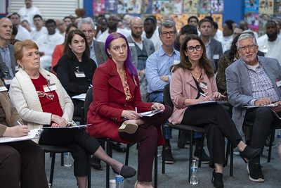 Panel of volunteers and business leaders attentively listening to PEP participants during a business plan pitch event.