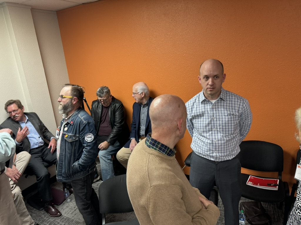 Community partners and volunteers engage in conversation at a Prison Entrepreneurship Program event supporting second chances and reentry collaboration