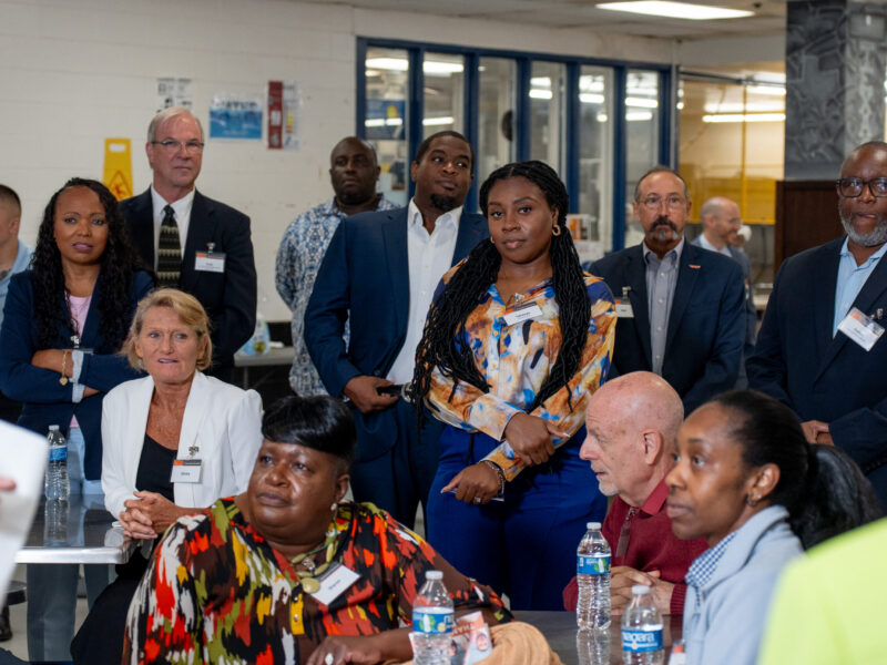 PEP volunteers and business professionals attentively observing a presentation inside a prison facility