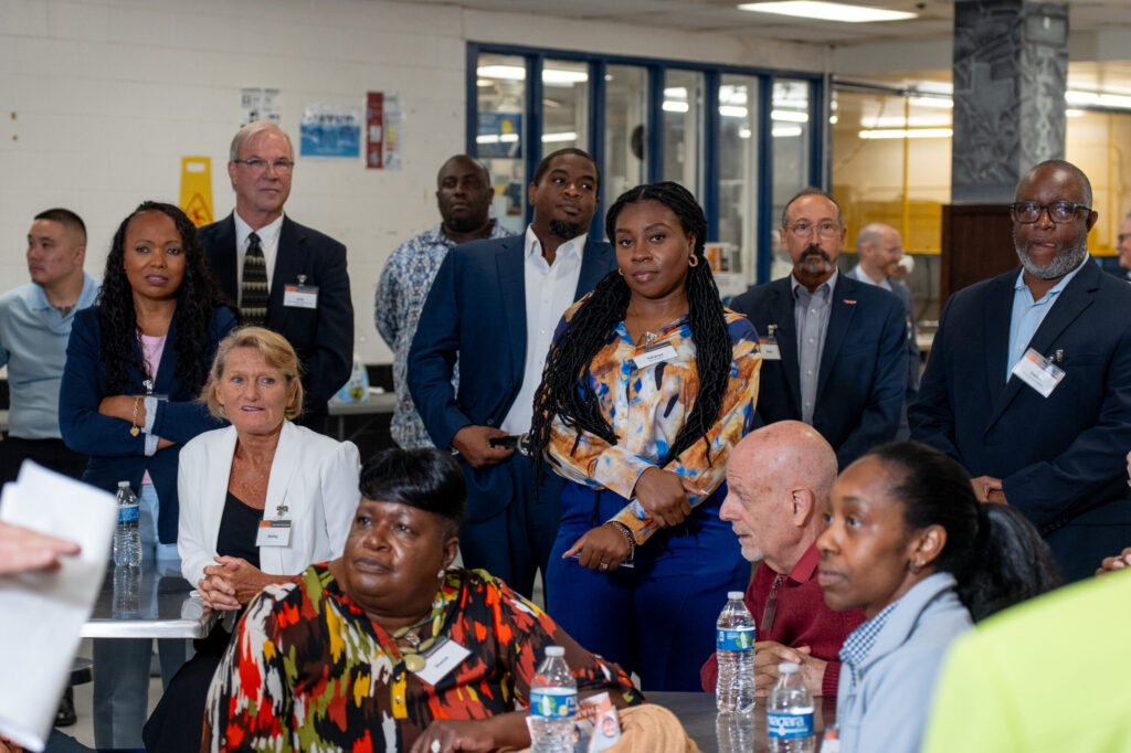 PEP volunteers and business professionals attentively observing a presentation inside a prison facility