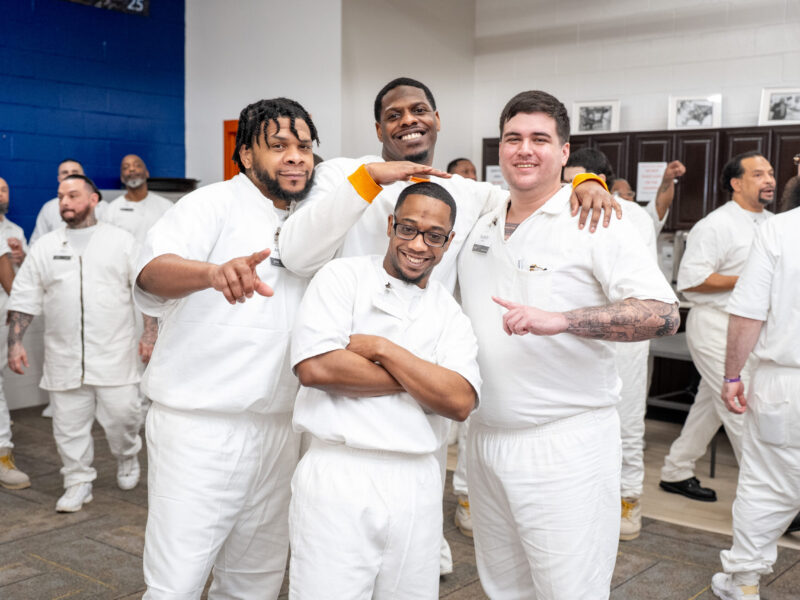 Prison Entrepreneurship Program participants pose together and celebrate brotherhood during a PEP class session inside a Texas correctional facility