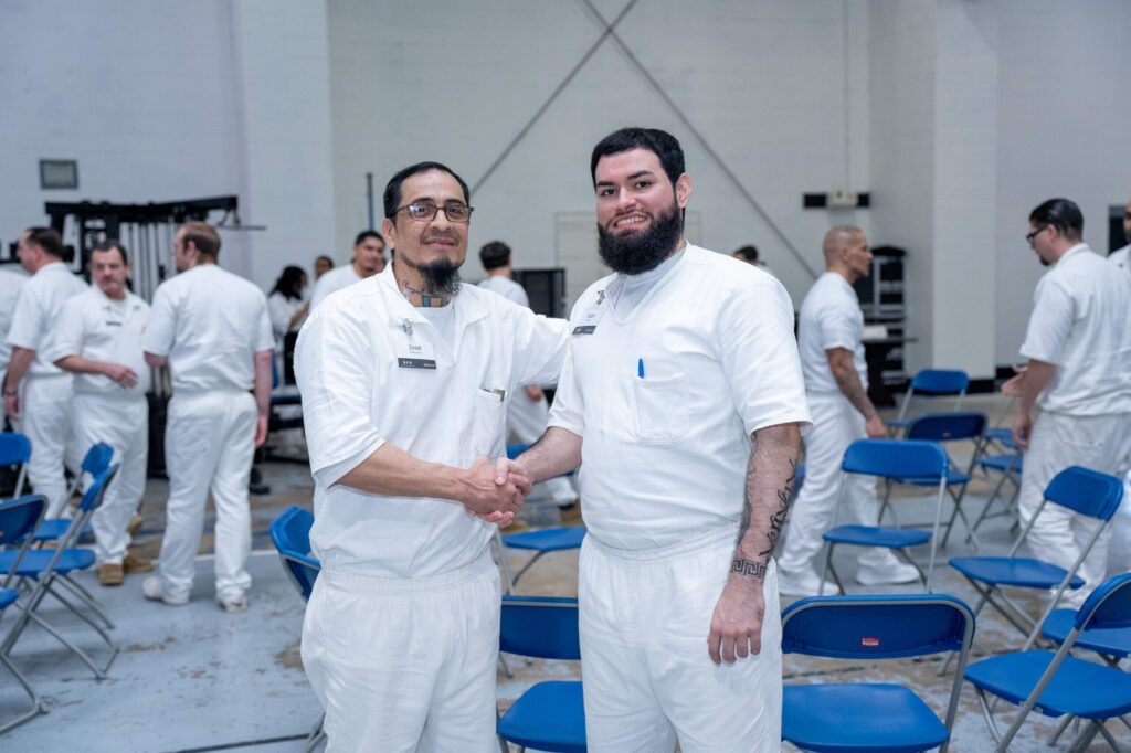 Prison Entrepreneurship Program participants shake hands and connect during a PEP class session inside a Texas prison unit