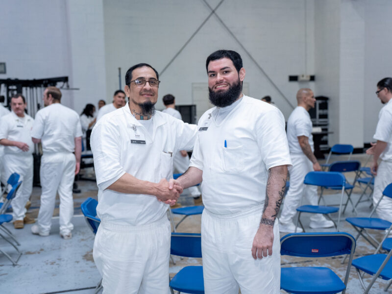 Prison Entrepreneurship Program participants shake hands and connect during a PEP class session inside a Texas prison unit