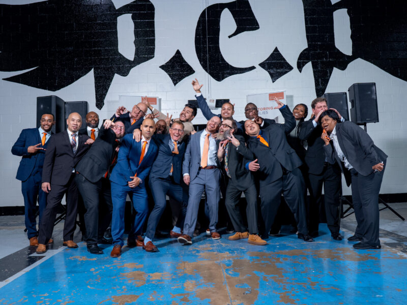 Prison Entrepreneurship Program mentors pose playfully in suits after a PEP ceremony celebrating transformation and restored purpose
