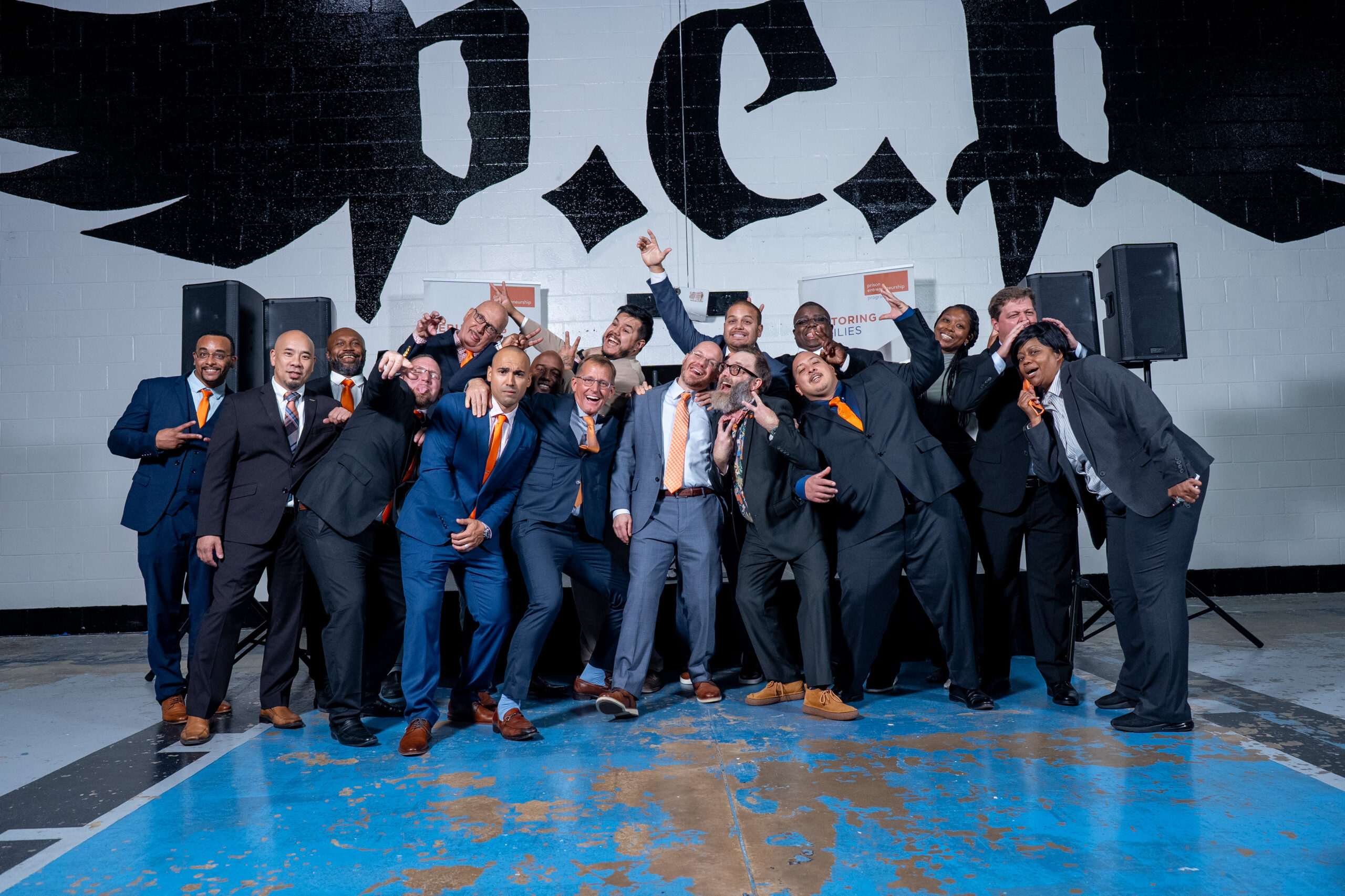 Prison Entrepreneurship Program mentors pose playfully in suits after a PEP ceremony celebrating transformation and restored purpose