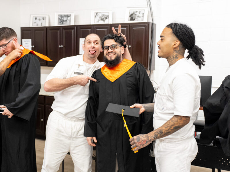 PEP graduates share a lighthearted moment backstage as they prepare for the cap and gown ceremony, smiling and supporting one another before the celebration