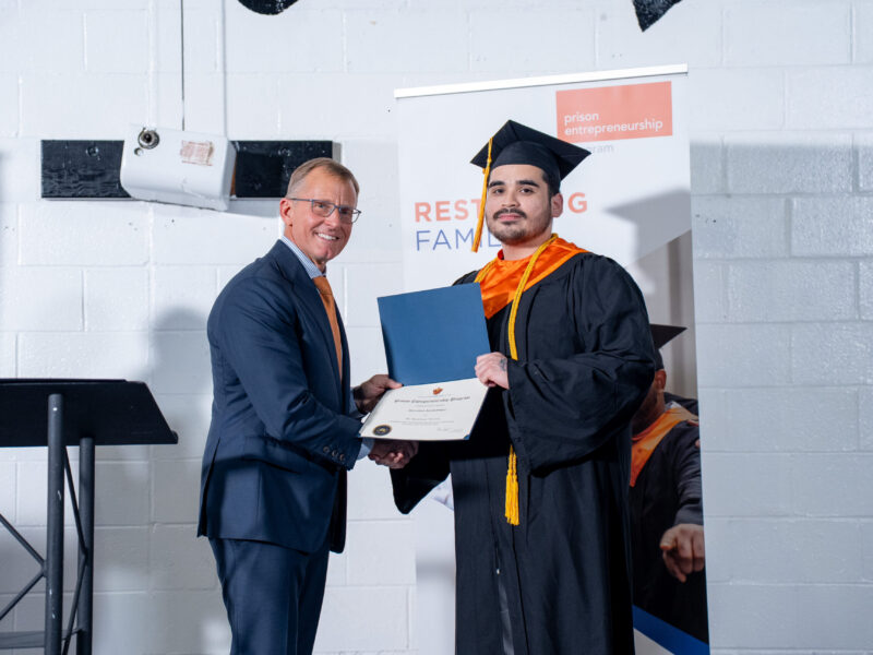 Prison Entrepreneurship Program graduate receives certificate during a PEP graduation ceremony focused on restoring families and second chances