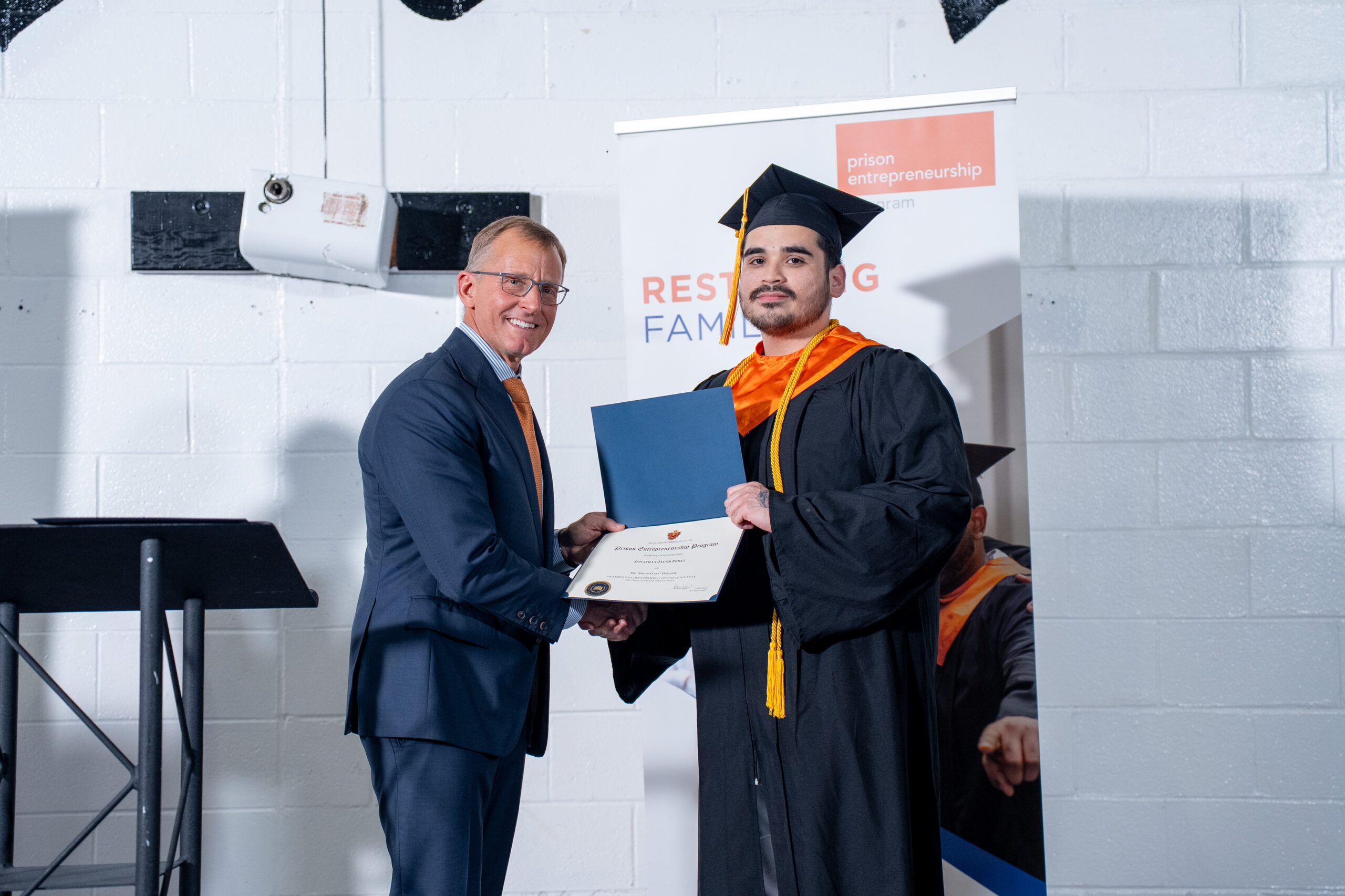 Prison Entrepreneurship Program graduate receives certificate during a PEP graduation ceremony focused on restoring families and second chances