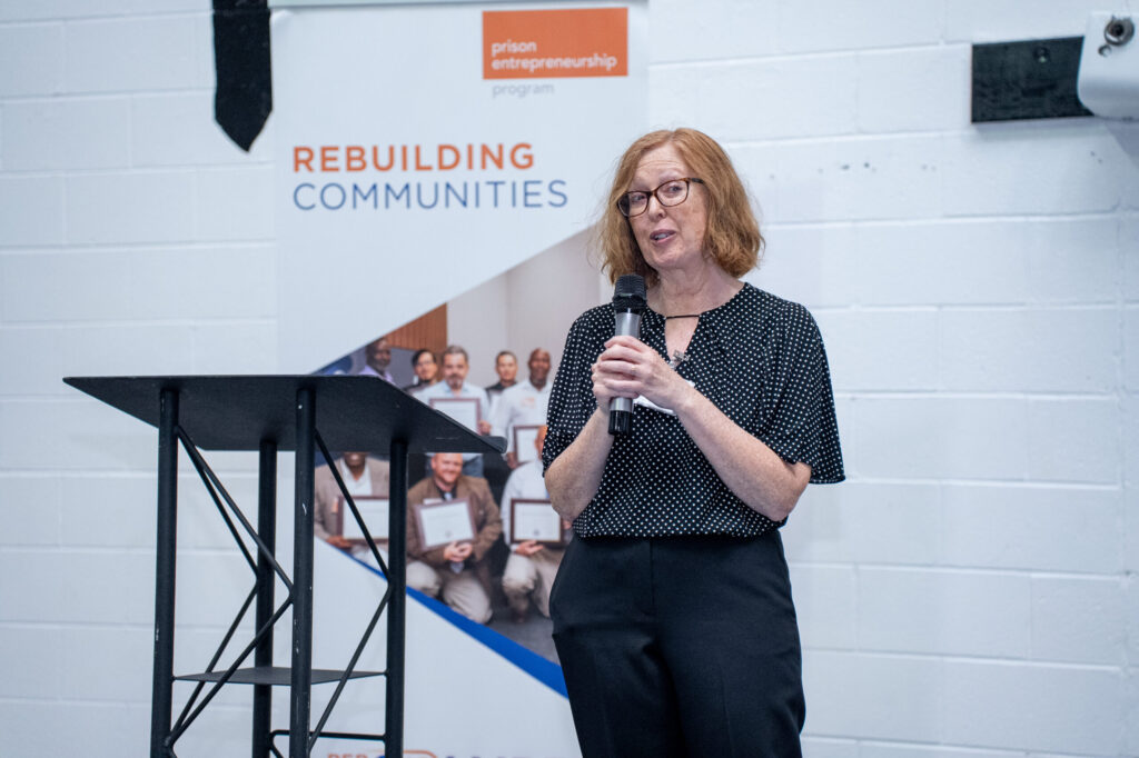 Prison Entrepreneurship Program volunteer speaker shares remarks during a PEP graduation focused on rebuilding communities