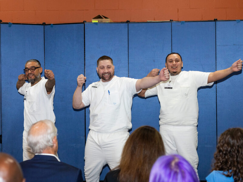 Three PEP participants performing a skit in front of an audience, showcasing confidence, teamwork, and creativity during a leadership development event
