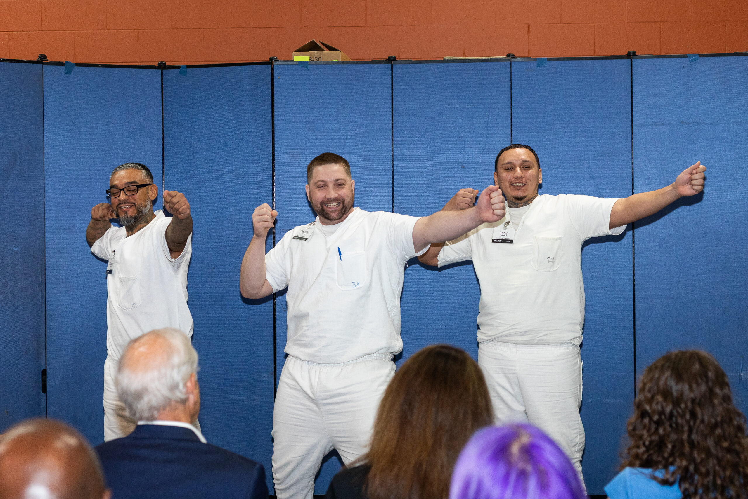Three PEP participants performing a skit in front of an audience, showcasing confidence, teamwork, and creativity during a leadership development event