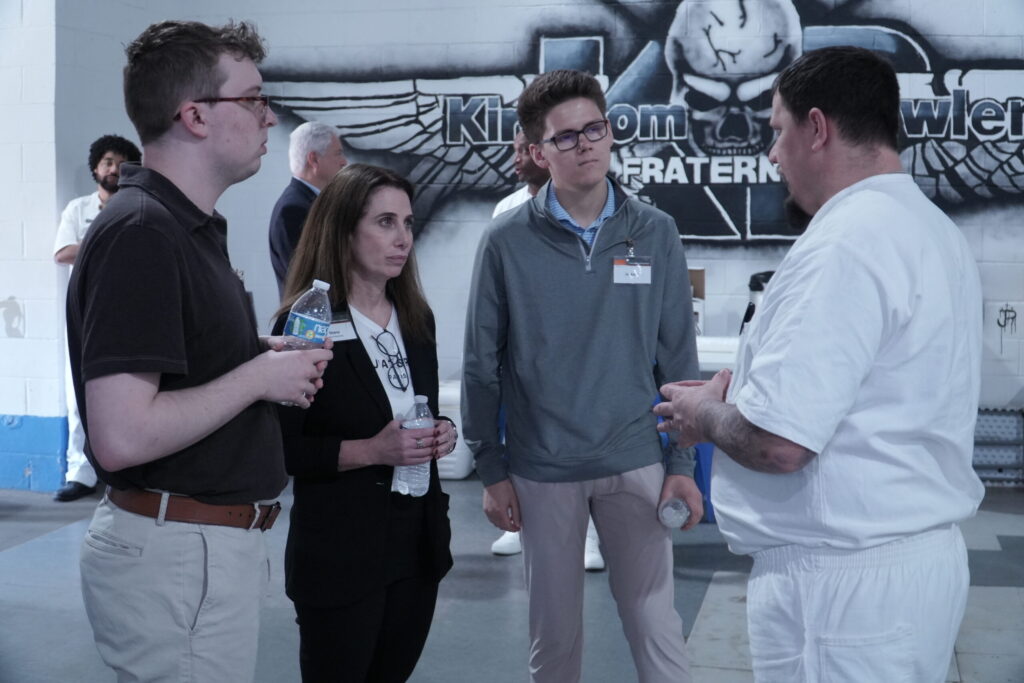 PEP participant discusses his business plan with a group of visiting business professionals during a mentoring event inside prison