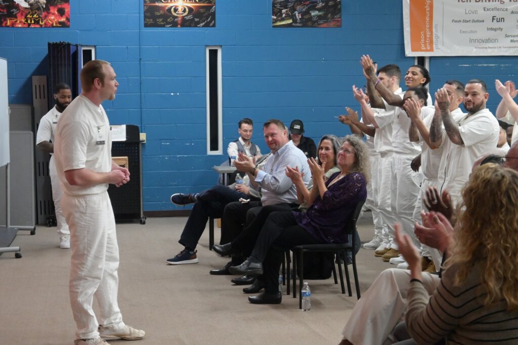 Prison Entrepreneurship Program participant delivers a business pitch to an audience of peers, volunteers, and staff during a PEP event inside a Texas prison