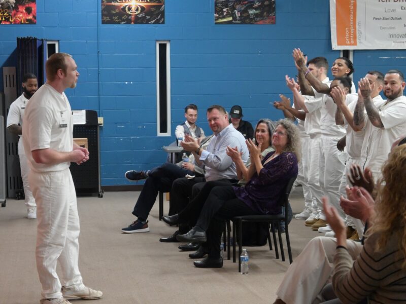 Prison Entrepreneurship Program participant delivers a business pitch to an audience of peers, volunteers, and staff during a PEP event inside a Texas prison