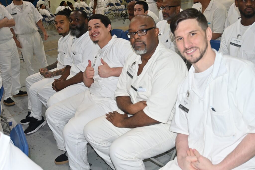 Prison Entrepreneurship Program participants seated and smiling during a PEP class session inside a Texas correctional facility