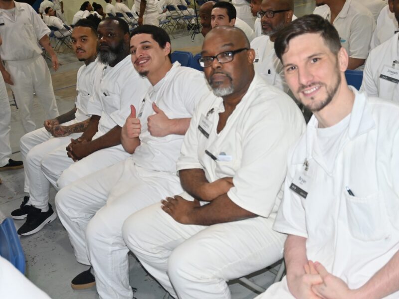 Prison Entrepreneurship Program participants seated and smiling during a PEP class session inside a Texas correctional facility