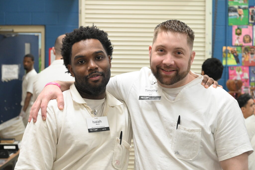 Prison Entrepreneurship Program participants smile and pose together during a PEP class session focused on leadership and transformation