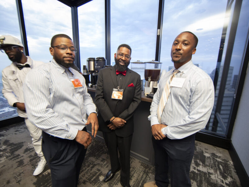 Formerly incarcerated PEP graduates network at a professional event overlooking the Dallas skyline following completion of the Prison Entrepreneurship Program