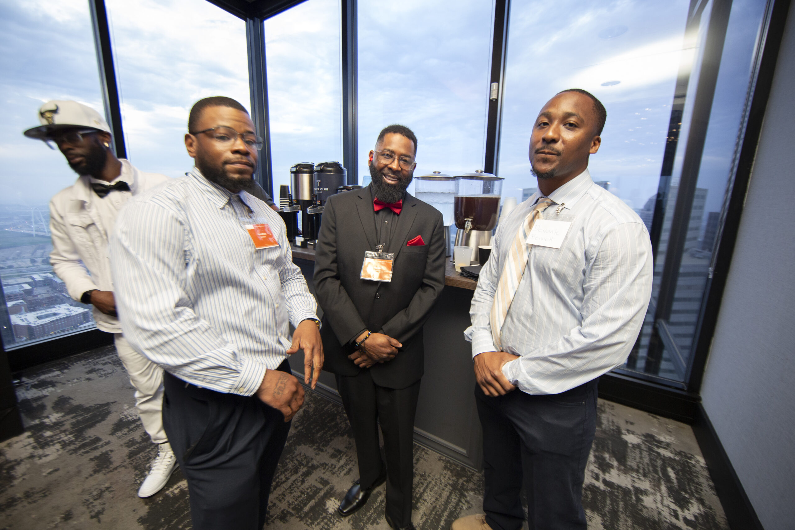 Formerly incarcerated PEP graduates network at a professional event overlooking the Dallas skyline following completion of the Prison Entrepreneurship Program