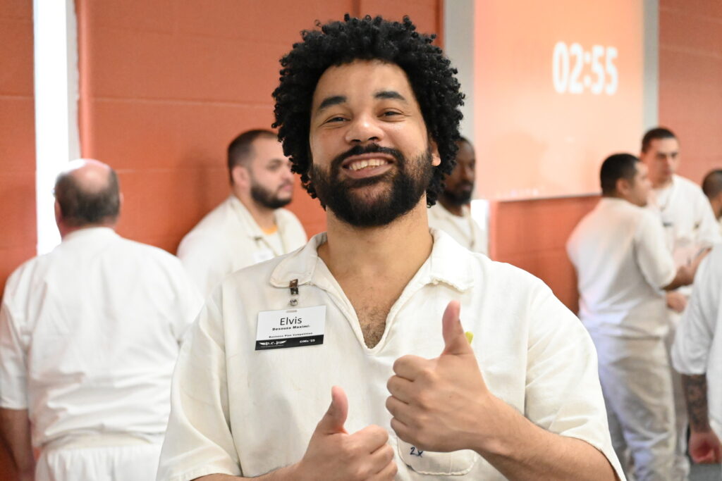 Prison Entrepreneurship Program participant smiles and gives thumbs up during a PEP workshop inside a Texas prison unit