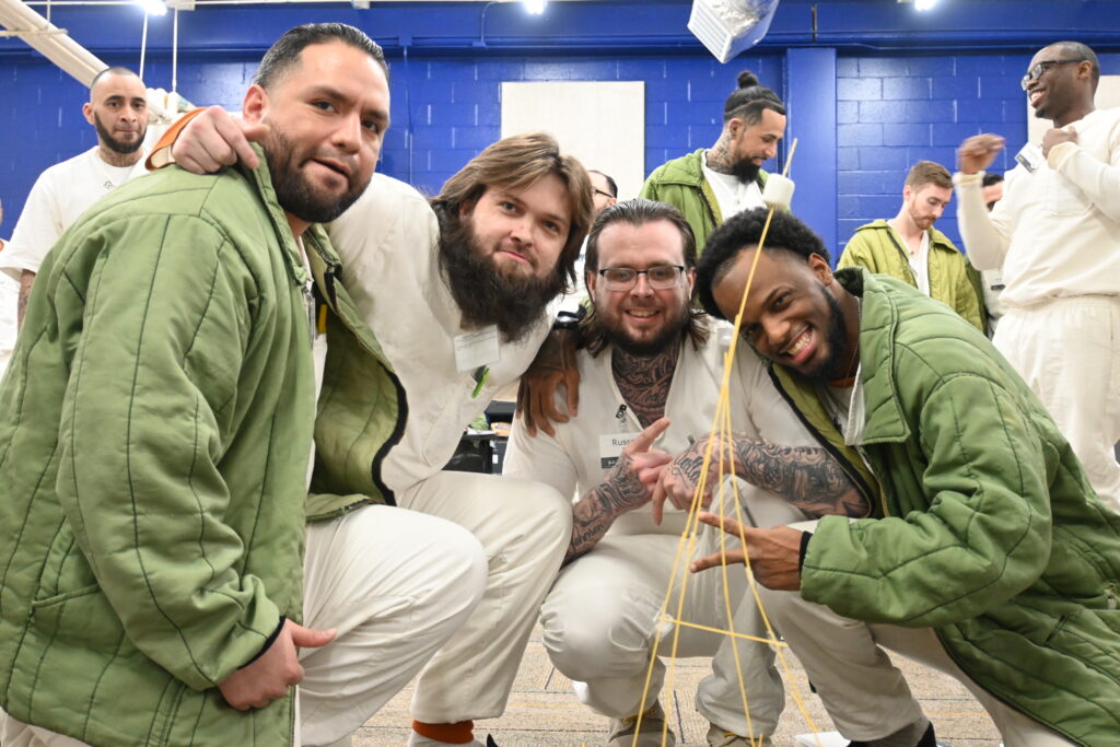 Participants in the Prison Entrepreneurship Program engage in a hands on team building challenge that develops collaboration, problem solving, and leadership skills essential for reentry and business success