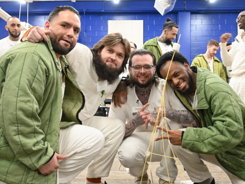 Participants in the Prison Entrepreneurship Program engage in a hands on team building challenge that develops collaboration, problem solving, and leadership skills essential for reentry and business success