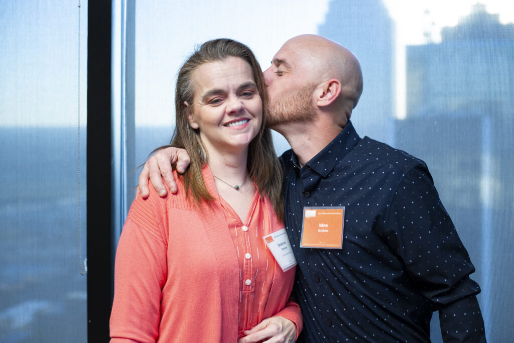 Man embraces and kisses a loved one during a Prison Entrepreneurship Program event, reflecting the program’s focus on family connection, restoration, and successful reentry