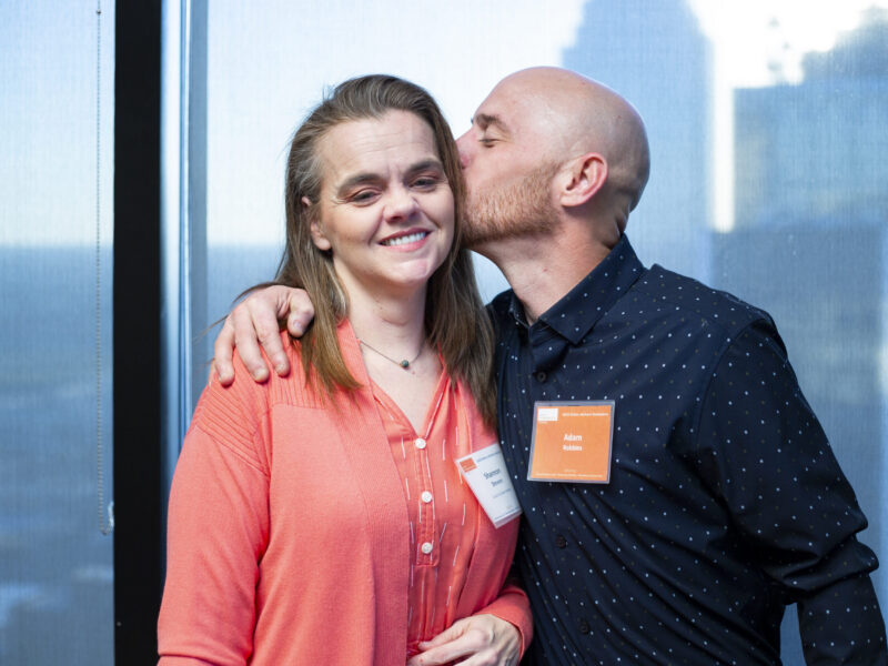 Man embraces and kisses a loved one during a Prison Entrepreneurship Program event, reflecting the program’s focus on family connection, restoration, and successful reentry
